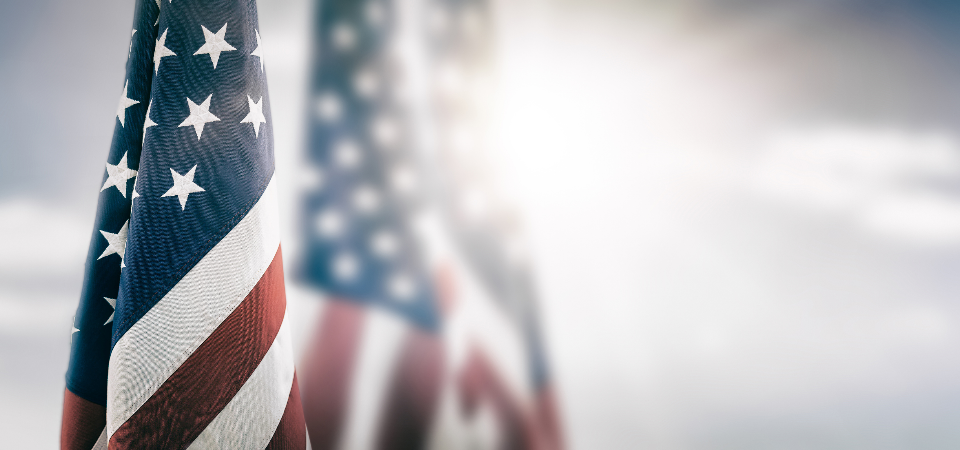 small american flags lined up with a bright light shining on them